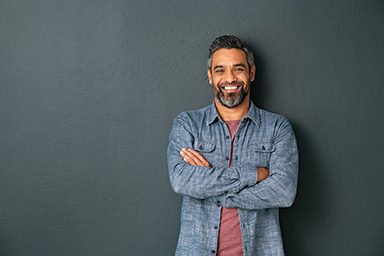 Smiling-mixed-race-mature-man-on-grey-background